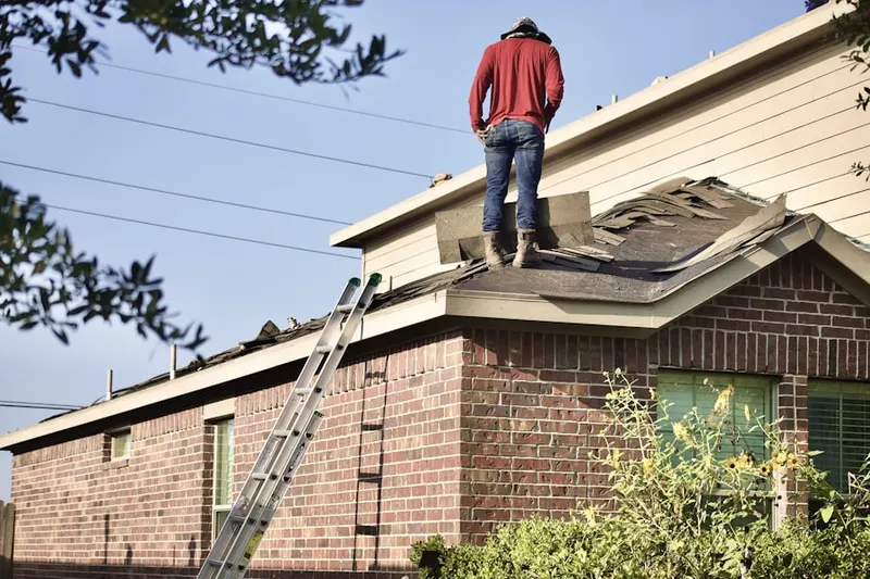 Professional roofer working on a residential roof in Ovid